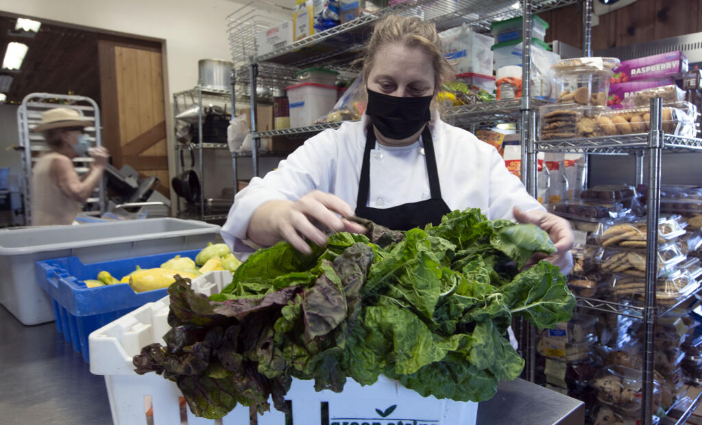 Executive sous chef Dawn McIntosh sorts through some chard, recently delivered from Sunray Farms, and squashes from Little Paradise Farm after a slow day of serving 96 breakfasts and 146 lunches at the Sonoma Springs Community Hall on Highway 12 on Wednesday, July 20, 2022. SOS has been one of many beneficiaries of the Catalyst Fund. (Robbi Pengelly/Index-Tribune)