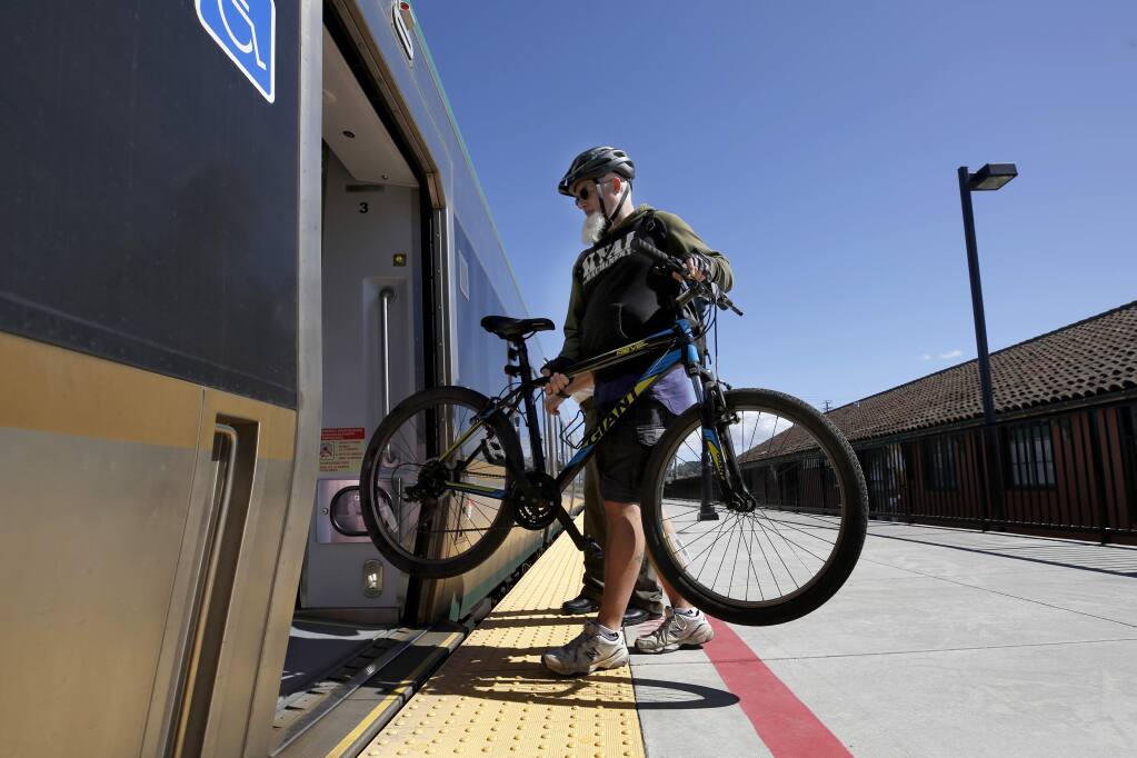 A cyclist loads his bicycle onto a northbound SMART train at the station in Petaluma, California, on Thursday, March 21, 2019. (BETH SCHLANKER/ PD)