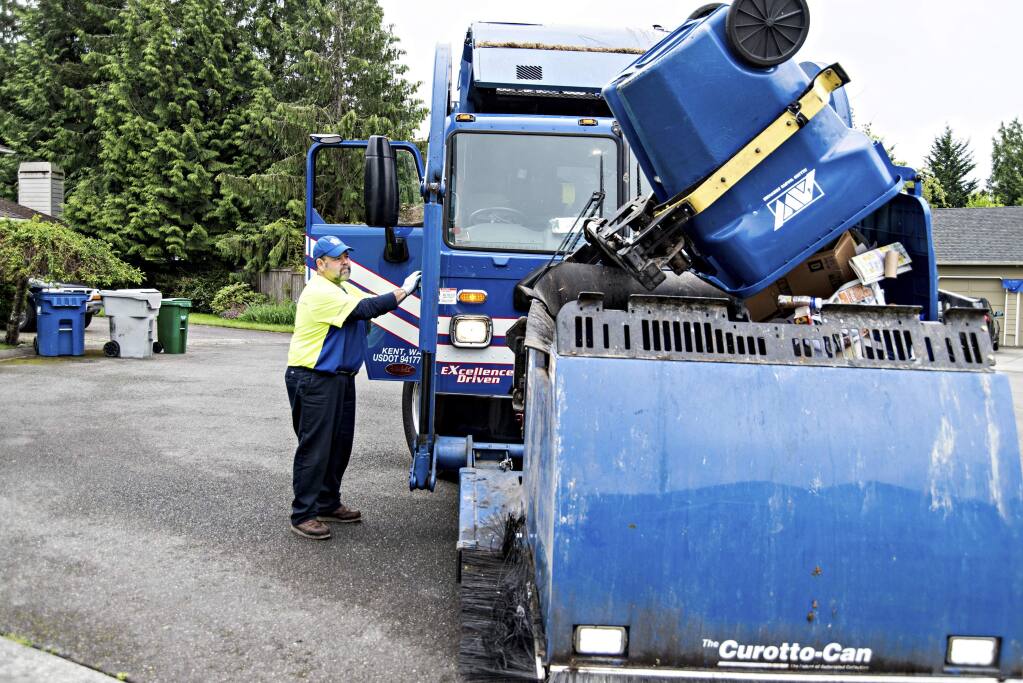 A Republic Services employee operates a truck that collects recycled materials in a residential neighborhood in Kent, Washington. (WIQAN ANG / New York Times)
