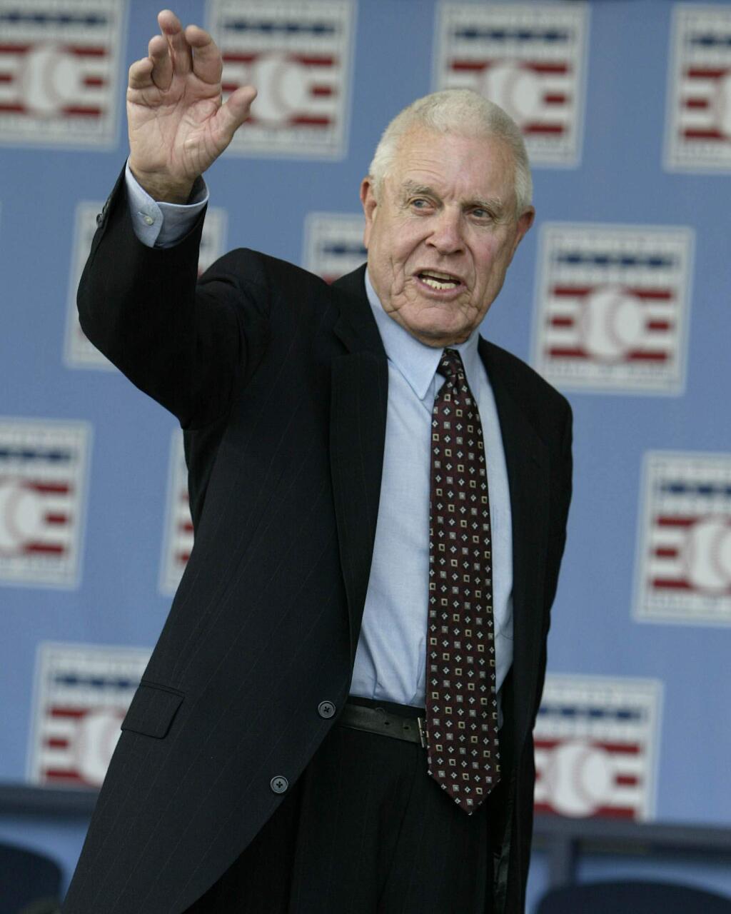 In this July 25, 2004, file photo, broadcaster Lon Simmons, the longtime voice of baseball in the San Francisco Bay area, waves at the end of the 2004 National Baseball Hall of Fame induction ceremonies in Cooperstown, N.Y. The Giants announced that Simmons had died Sunday, April 5, 2015. He was 91. (AP Photo/John Dunn, File)