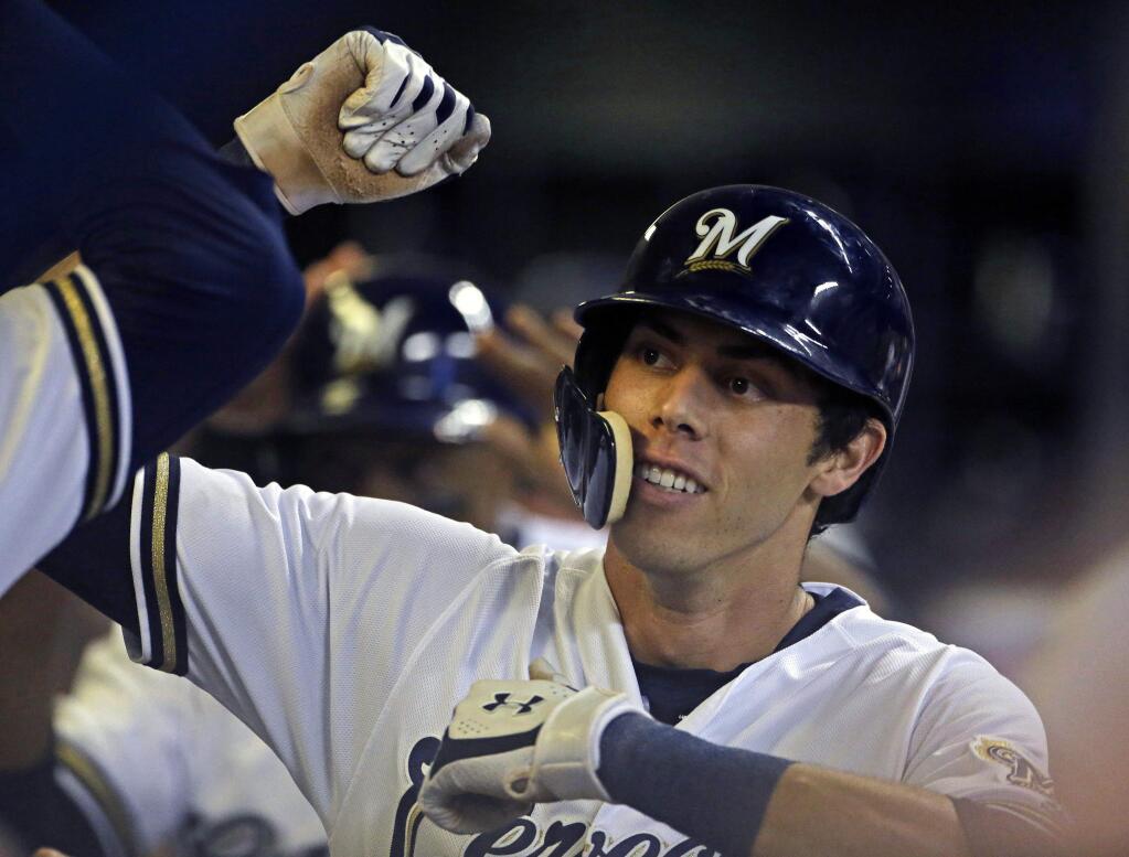 In this Monday, Sept. 17, 2018 file photo, the Milwaukee Brewers' Christian Yelich is congratulated by teammates in the dugout after hitting a two-run home run during the fifth inning against the Cincinnati Reds in Milwaukee. (AP Photo/Aaron Gash, File)