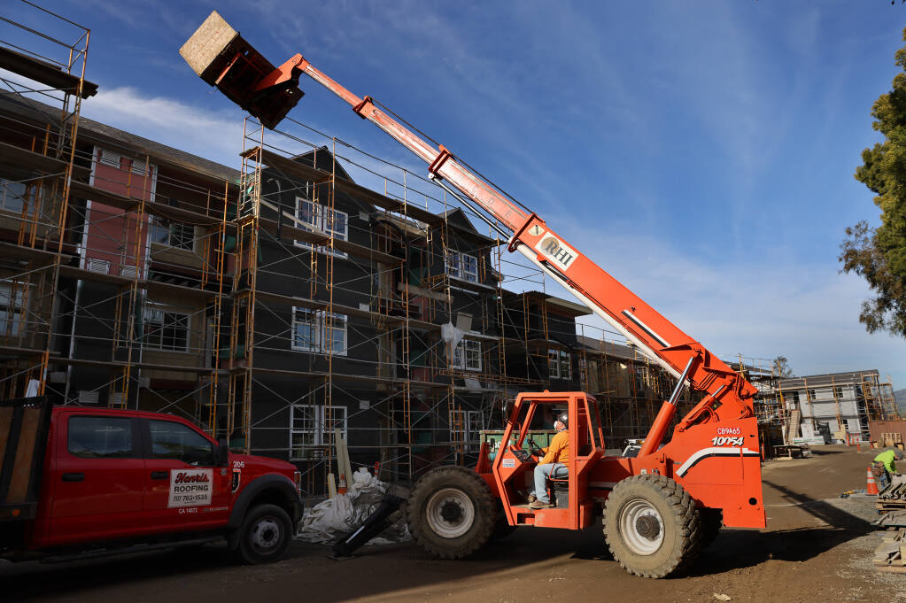 Mike Miller operates a boom forklift while working to complete the River City Senior Apartments, a new PEP Housing residential complex, in Petaluma on Thursday, Jan. 13, 2022. (Beth Schlanker/The Press Democrat)