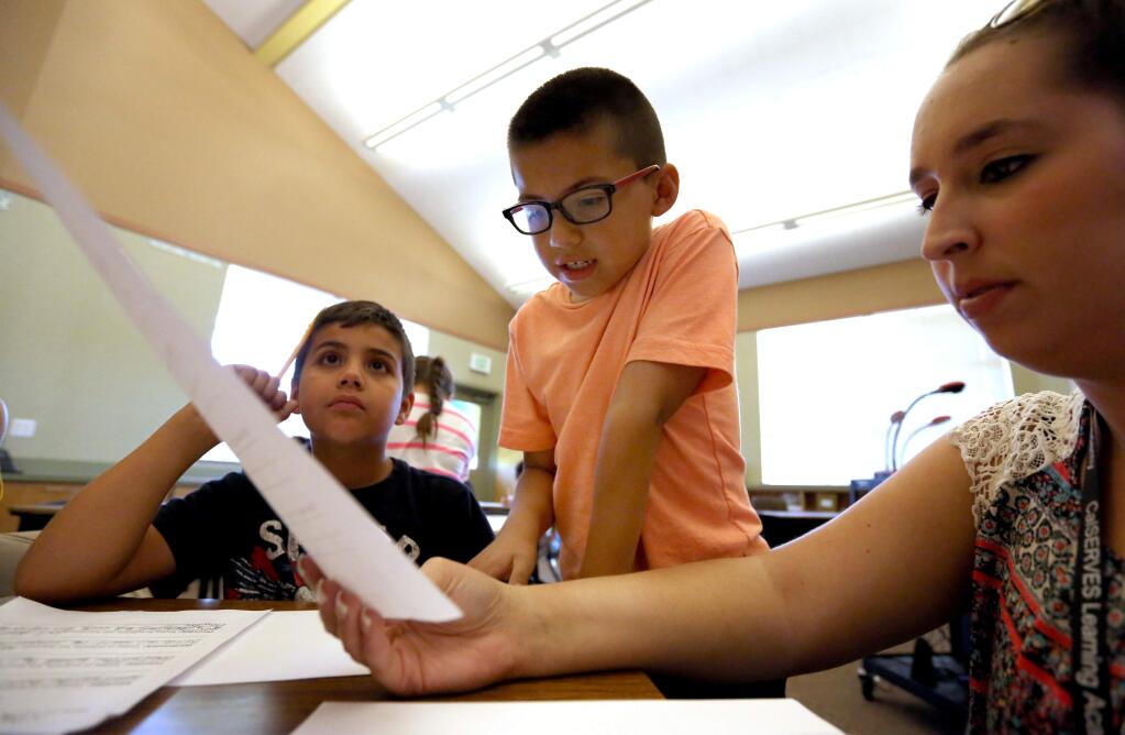 Amanda Houlemard, right, the lead instructor at Taylor Mountain School Academy teaches second grade science to Isaac Aguilar, 7, center, and Max Reyes, 7, left, Thursday, June 4, 2015. (CRISTA JEREMIASON / The Press Democrat)