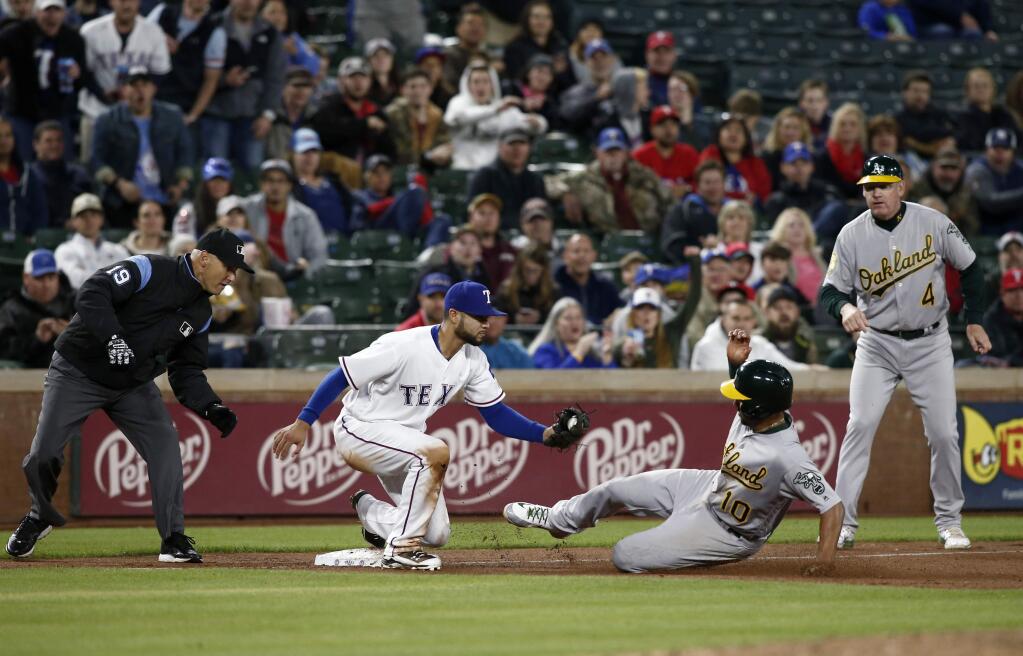 Oakland Athletics' Marcus Semien (10) is out as Texas Rangers third baseman Isiah Kiner-Falefa (9) prepares to apply the tag as third base umpire Vic Carapazza and third base coach Matt Williams (4) watch during the eighth inning of a baseball game Wednesday, April 25, 2018, in Arlington, Texas. (AP Photo/Mike Stone)