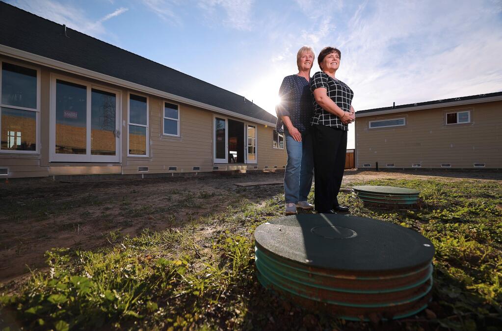 Gena, right, and Sheri Jacob stand above their septic system in the backyard of their rebuilt home in Larkfield. Their home will be tied into a new sewage system in 2020. Gena is one of the Larkfield Estates residents who spearheaded an effort to establish a sewer system in the unincorporated neighborhood in the aftermath of the Tubbs fire. (Christopher Chung/ The Press Democrat)