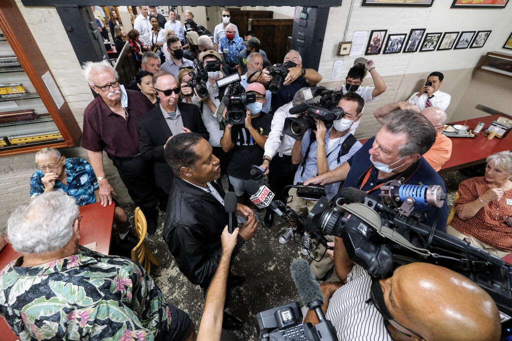 Republican conservative radio show host Larry Elder, is surrounded by media while he visiting Philippe The Original Deli during a campaign for the California gubernatorial recall election on Monday, Sept. 13, 2021, in Los Angeles. (AP Photo/Ringo H.W. Chiu)
