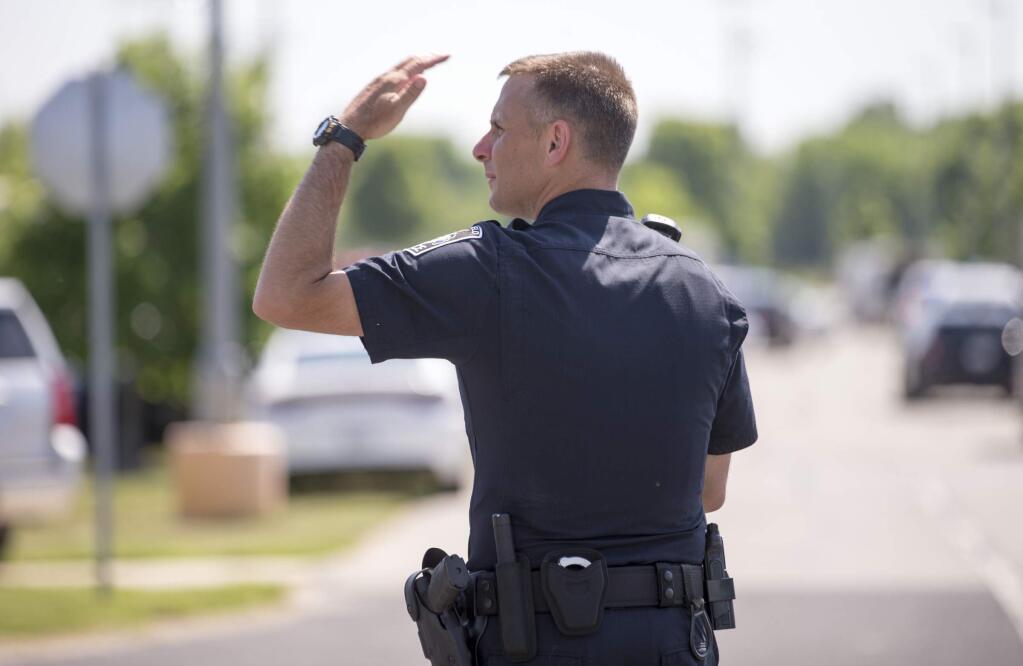 A police officer directs traffic after a shooting at Noblesville West Middle School in Noblesville, Ind., on Friday, May 25, 2018. A male student opened fire at the suburban Indianapolis school wounding another student and a teacher before being taken into custody, authorities said. (Robert Scheer/The Indianapolis Star via AP)