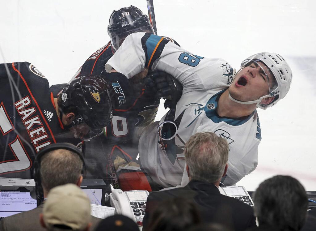 San Jose Sharks right winger Timo Meier, right, and Anaheim Ducks center Rickard Rakell, left, battle against the boards in the first period of an NHL hockey game in Anaheim, Calif., Sunday, Feb. 11, 2018. (AP Photo/Reed Saxon)