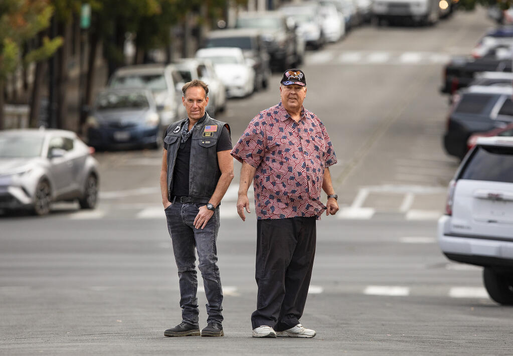 Longtime Petaluma Veterans Day Parade organizer Steve Kemmerle, right, has passed the reins to Joe Noriel after this year's parade was canceled because of the coronavirus. The parade route heads down Kentucky Street, shown behind the pair. (John Burgess / The Press Democrat)