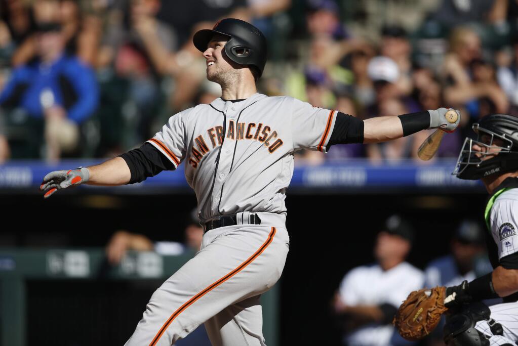 San Francisco Giants' Buster Posey , left, follows the flight of his three-run home run with Colorado Rockies catcher Dustin Garneau in the eighth inning Saturday, May 28, 2016, in Denver. (AP Photo/David Zalubowski)