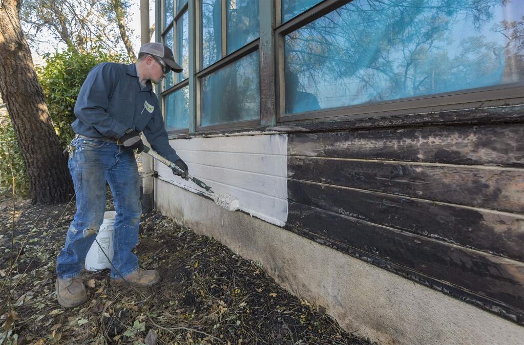 Trevor Smith, with the SVUSD, repairs one wall that was burnt at the Dunbar Elementary School. (Photo by Robbi Pengelly/Index-Tribune)