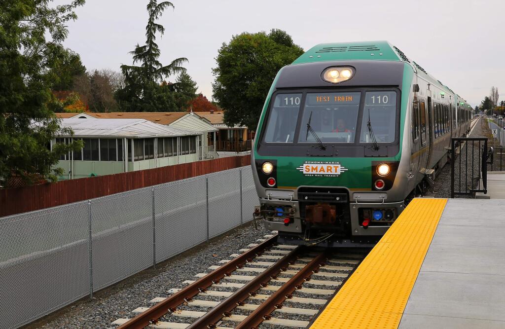 A northbound SMART test train rolls past the Valley Village mobile home park as it pulls into the Rohnert Park platform, south of Rohnert Park Expressway, in Rohnert Park, on Monday, December 5, 2016. (Christopher Chung/ The Press Democrat)