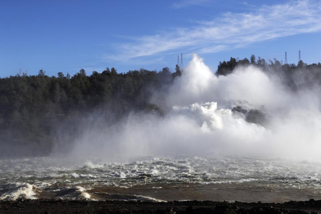 Water gushes from the Oroville Dam's main spillway on Tuesda. (MARCIO JOSE SANCHEZ / Associated Press)