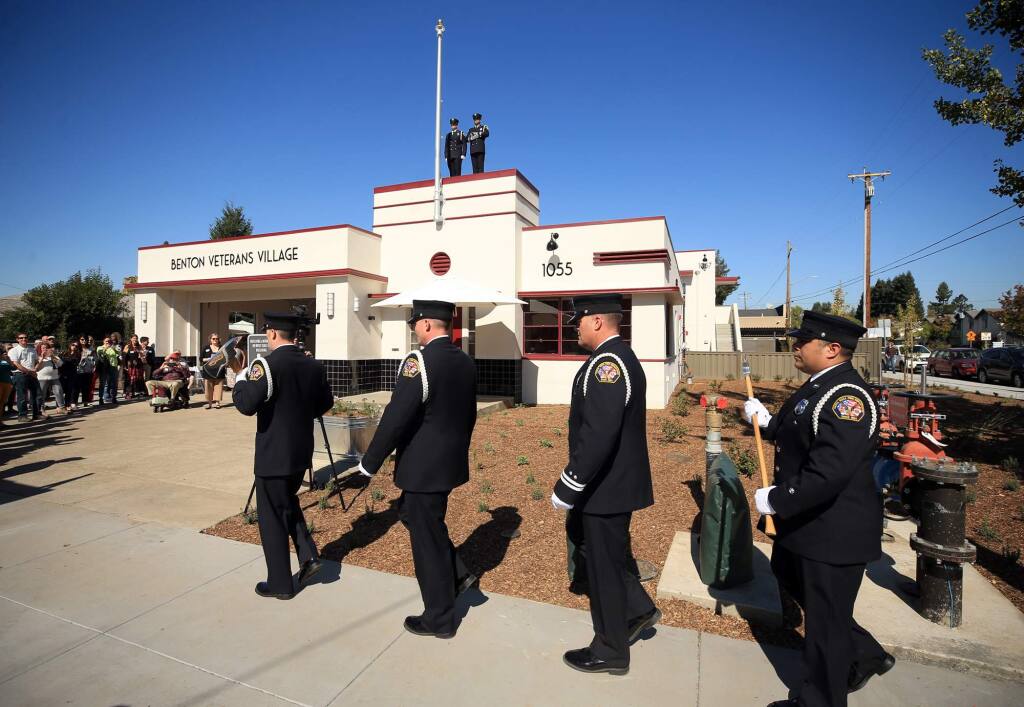 The Santa Rosa Fire Department honor guard, from left, Chris Matthies, Chris Roberts, Scott Byrn and Teddy Day start off the grand opening of the Benton Veterans Village in Santa Rosa, Friday, October 19, 2018 in Santa Rosa. On top of the building presenting colors are Andrew Vallely, left and Mike Musgrove. (Kent Porter / The Press Democrat) 2018