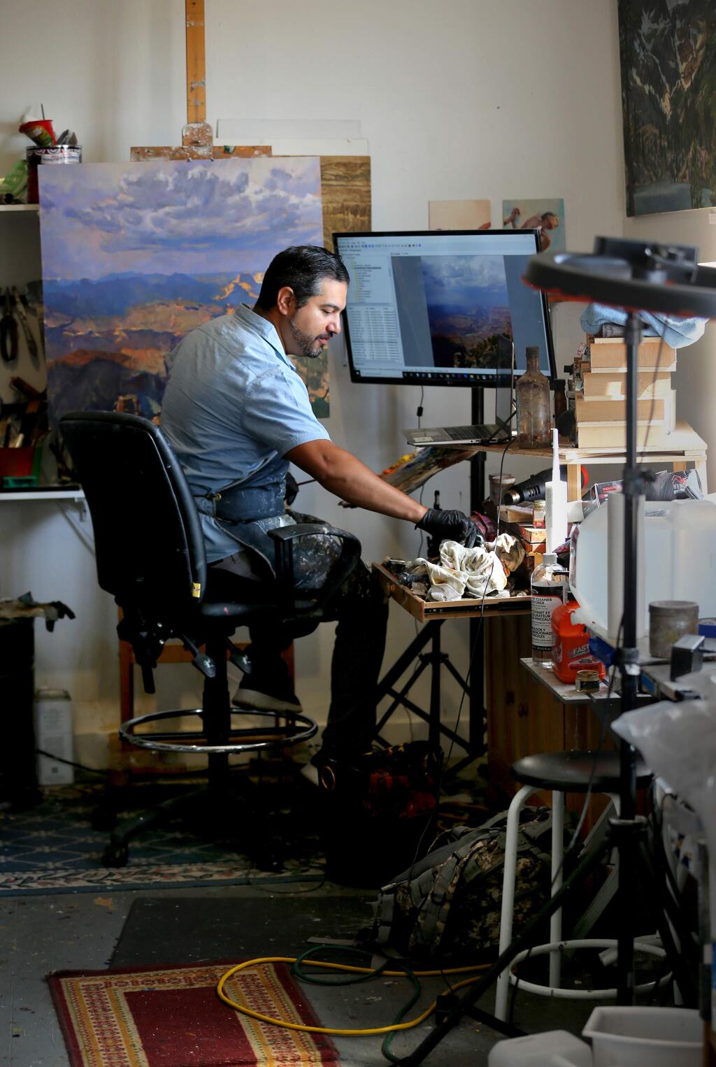 Sergio Lopez works on a painting of the Grand Canyon in his studio in Santa Rosa on Thursday, Aug. 29, 2019. (BETH SCHLANKER/ The Press Democrat)