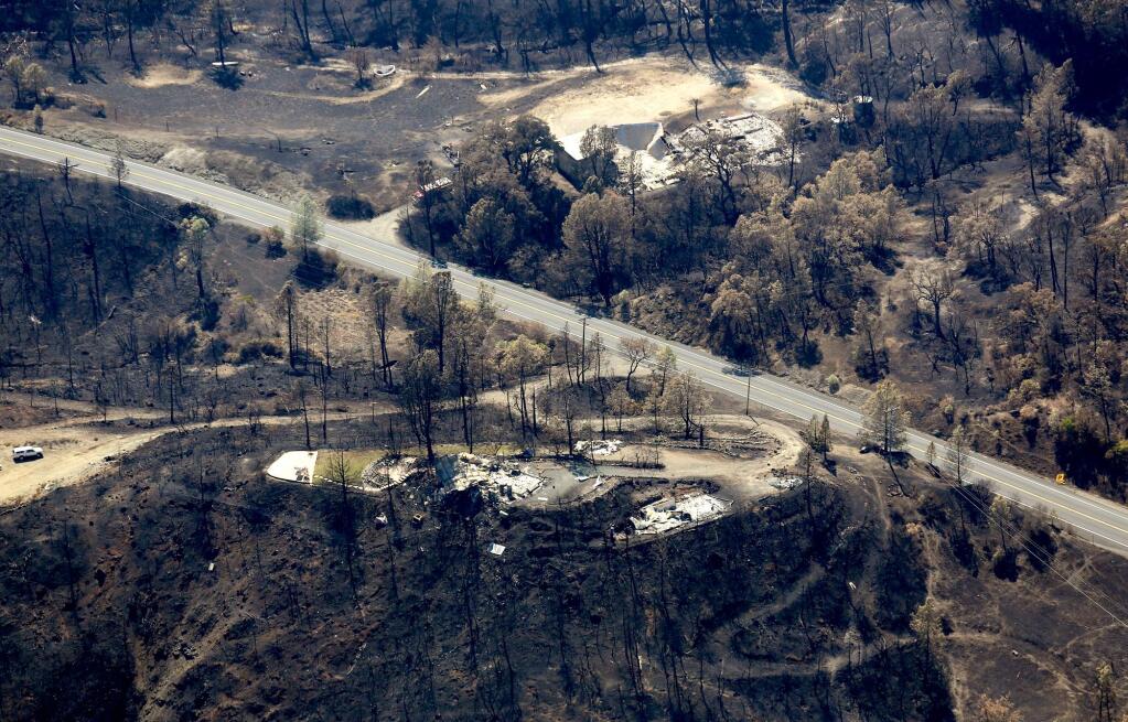 Highway 175 runs through the drainage of Putah Creek which shows a home in the foreground and a business, background, showing the devastation wrought by the Valley fire, Friday Sept. 18, 2015. (Kent Porter / Press Democrat) 2015