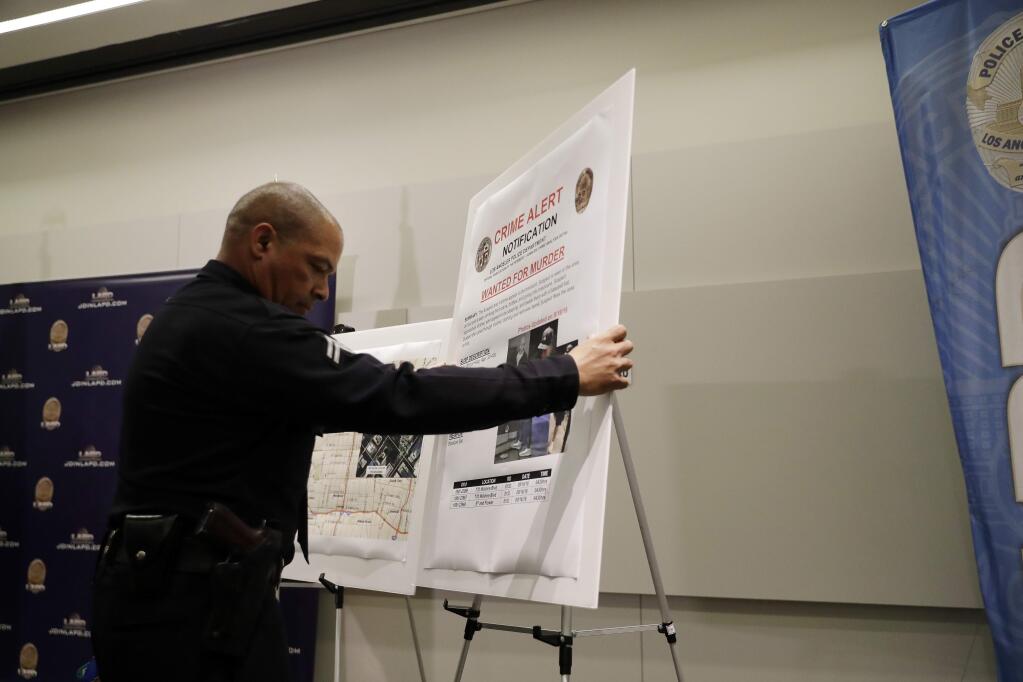 A crime alert bulletin is posted during a press conference at LAPD headquarters Tuesday, Sept. 25, 2018, in Los Angeles. A man arrested on suspicion of beating a Southern California homeless man into unconsciousness and suspected in six other attacks - three of them fatal - also was being investigated in the disappearances of two of the suspect's Texas relatives, officials said Tuesday. (AP Photo/Marcio Jose Sanchez)