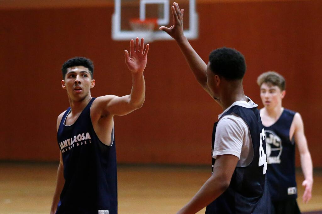 SRJC's Ryan Perez, left, gets a high-five from Ahmad Chambers after Perez drained a three-pointer during practice at Haehl Pavilion in Santa Rosa on Tuesday, March 5, 2019. (Alvin Jornada / The Press Democrat)