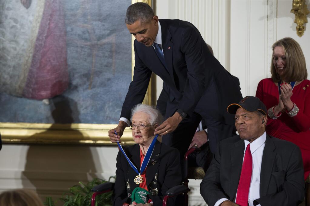FILE - In this Nov. 24, 2015 photo, Willie Mays, right, looks on as President Barack Obama presents the Presidential Medal of Freedom to NASA mathematician Katherine Johnson during a ceremony in the East Room of the White House, in Washington. Johnson, a mathematician on early space missions who was portrayed in film 'Hidden Figures,' about pioneering black female aerospace workers, died Monday, Feb. 24, 2020. (AP Photo/Evan Vucci, File)