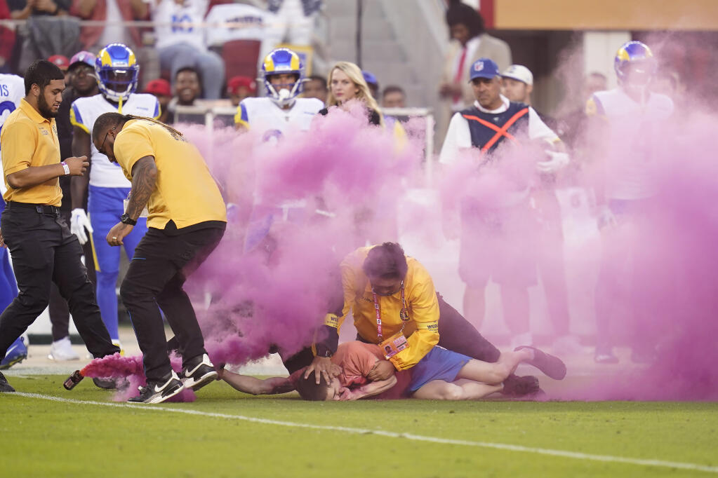 A protester is held down by security after running on the field during the first half of an NFL football game between the San Francisco 49ers and the Los Angeles Rams in Santa Clara, Calif., Monday, Oct. 3, 2022. (AP Photo/Godofredo A. Vásquez)