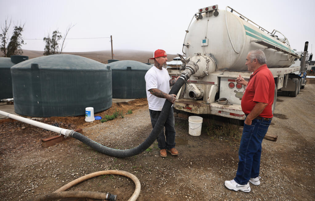 Two Rock dairy rancher Don DeBernardi, right, hired Scott Bruno to drive the ranch water truck to bring in 30,000 gallons of water a day to supply water to his dairy cows. Most of DeBernardi's livestock ponds are dry, Friday, Sept. 10, 2021. (Kent Porter / The Press Democrat)