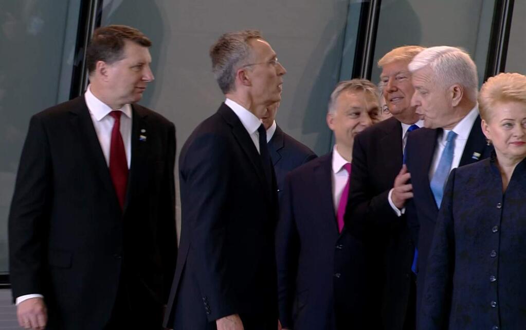 In this image taken from NATO TV, Montenegro Prime Minister Dusko Markovic, second right, appears to be pushed by US President Donald Trump as they were given a tour of NATO's new headquarters after taking part in a group photo, during a NATO summit of heads of state and government in Brussels on Thursday, May 25, 2017. (NATO TV via AP)
