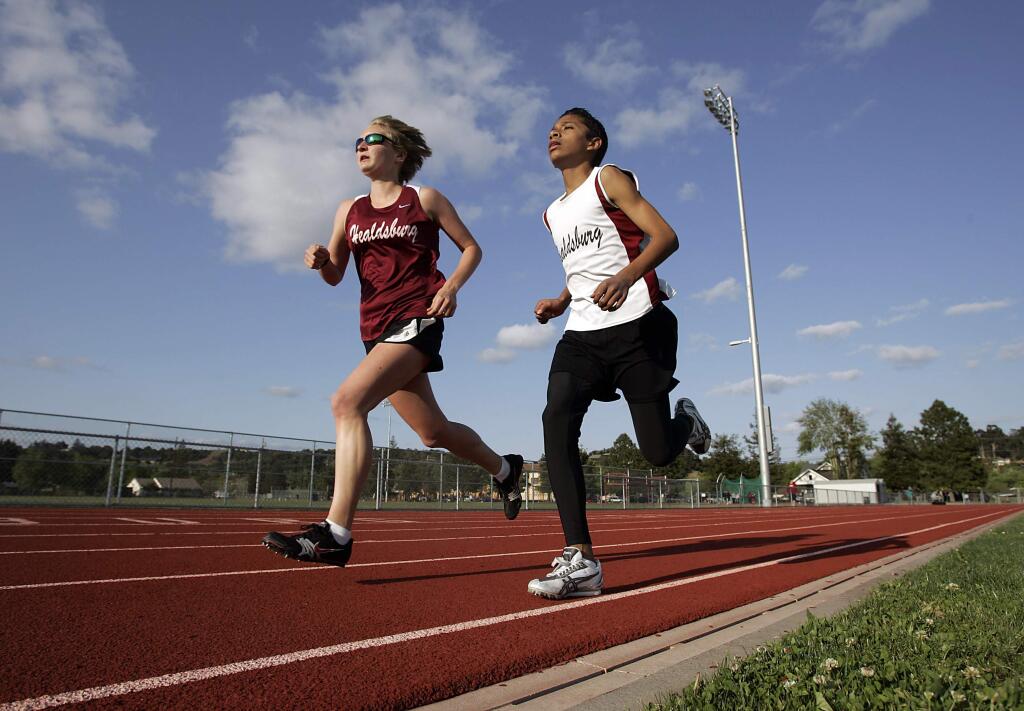 LEDE--Healdsburg varsity track runner Sarah Sumpter, left, races alongside JV boys runner Luis Balderas in the 3200 meter race during a meet against El Molino on Wednesday, April 23, 2008. Sumpter, a senior who is recovering from an eating disorder, finished in a time of 11:31 in her first race of the season, which was the last regular season meet. (Press Democrat/ Christopher Chung)