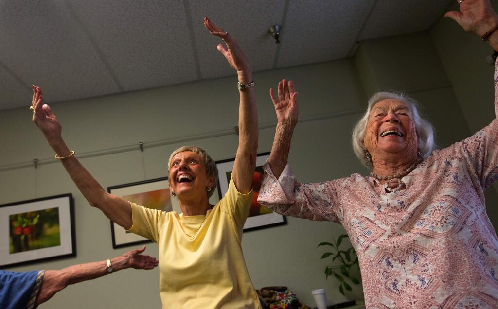 Donna Manahan, left, and Colleen Lala laugh while stretching during a Laughter Yoga class at the Healdsburg Senior Center on Monday, July 30, 2018. (photo by John Burgess/The Press Democrat)
