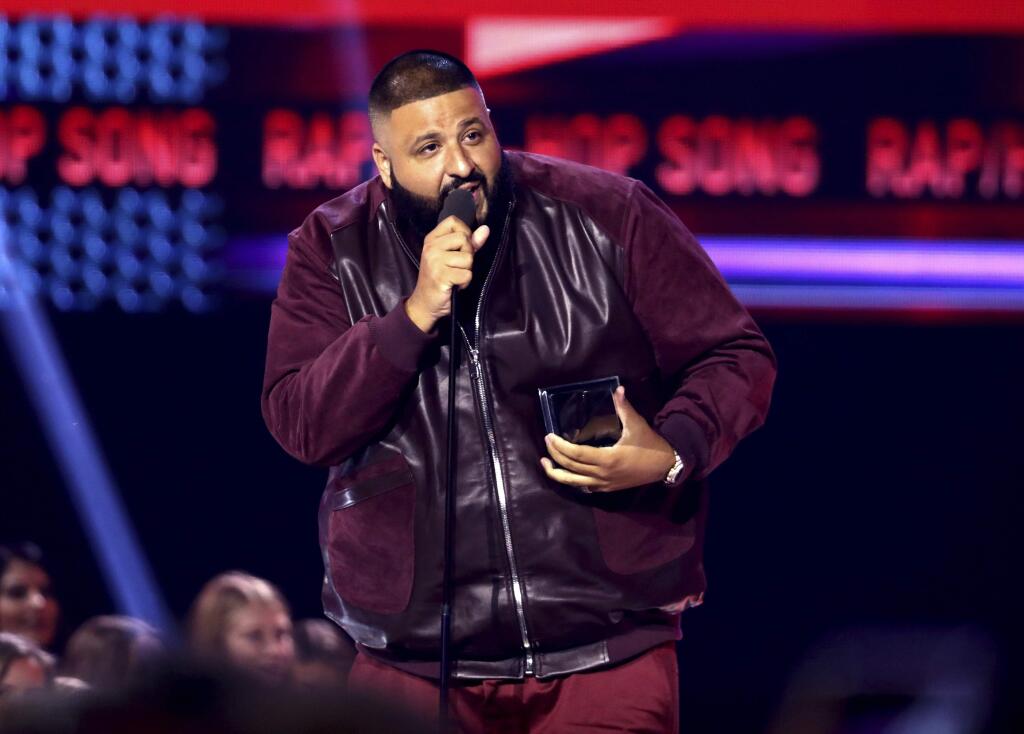 FILE - In this Sunday, Nov. 19, 2017, file photo, DJ Khaled accepts the award for favorite song rap/hip-hop for 'I'm the One' at the American Music Awards at the Microsoft Theater in Los Angeles. Weight Watchers International climbed after it struck a deal with producer and recording artist DJ Khaled, who will represent the brand to millions of follows on Snapchat, Twitter, Instagram and Facebook. (Photo by Matt Sayles/Invision/AP, File)