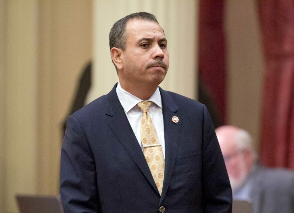 FILE - In this Jan. 3, 2018 file photo, state Sen. Tony Mendoza, D-Artesia, stands at his desk after announcing that he will take a month-long leave of absence while an investigation into sexual misconduct allegations against him are completed, in Sacramento, Calif. He ultimately resigned his seat, but is again running for the seat in the upcoming California primary election. (AP Photo/Steve Yeater, File)