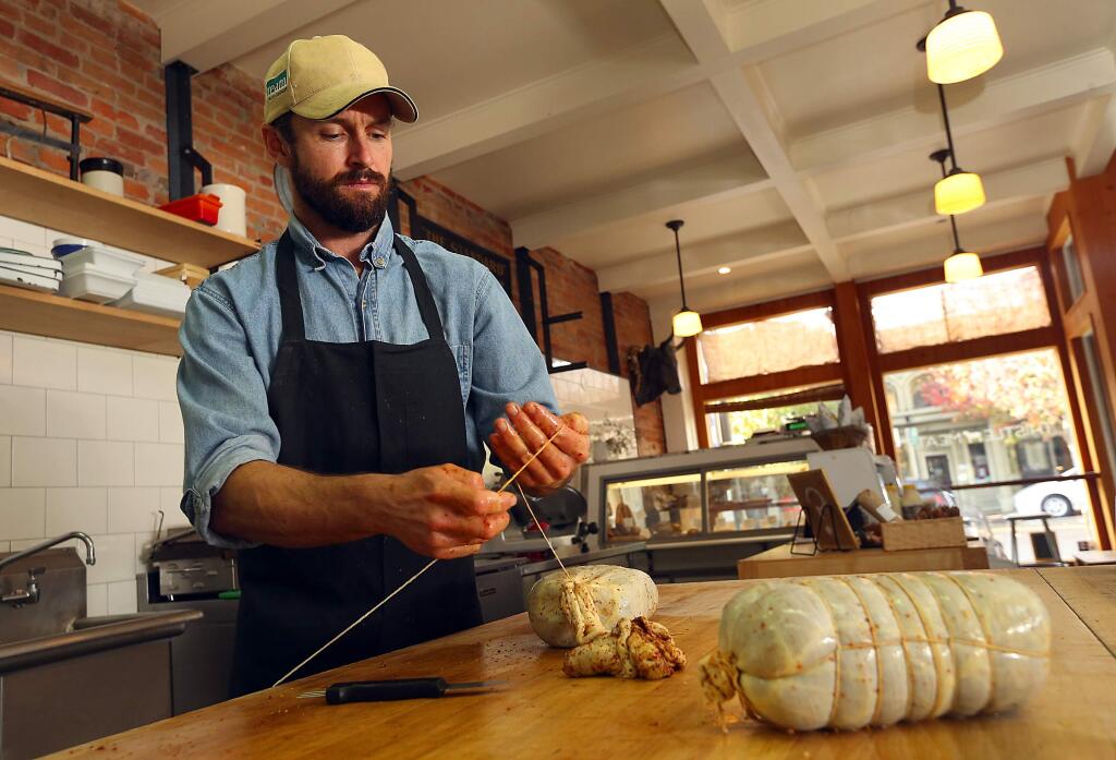 Salumiere Aaron Gilliam wraps aged pork shoulder to cure into copoa at Thistle Meats in Petaluma. (JOHN BURGESS / The Press Democrat)