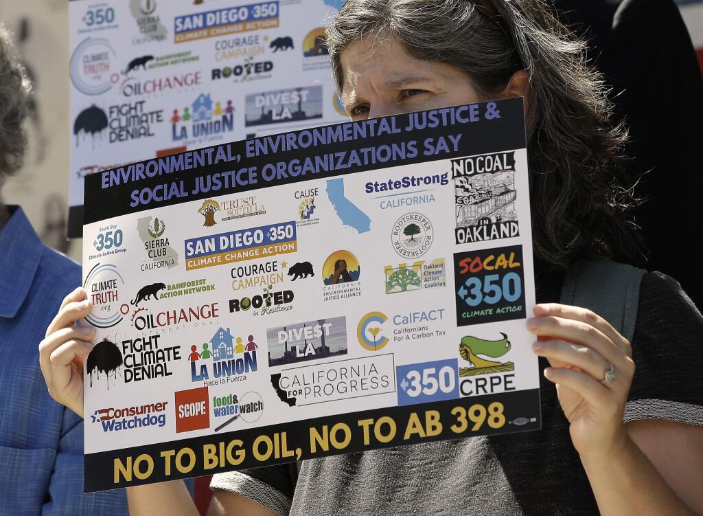 Catherine Garoupa joins others critical of Gov. Jerry Brown's cap-and-trade program, calling for defeat of the bill at a news conference, Monday, July 17, 2017, in Sacramento, Calif. California lawmakers are expected to vote Monday on AB398, Monday, which critics say is too friendly to the oil industry. (AP Photo/Rich Pedroncelli)