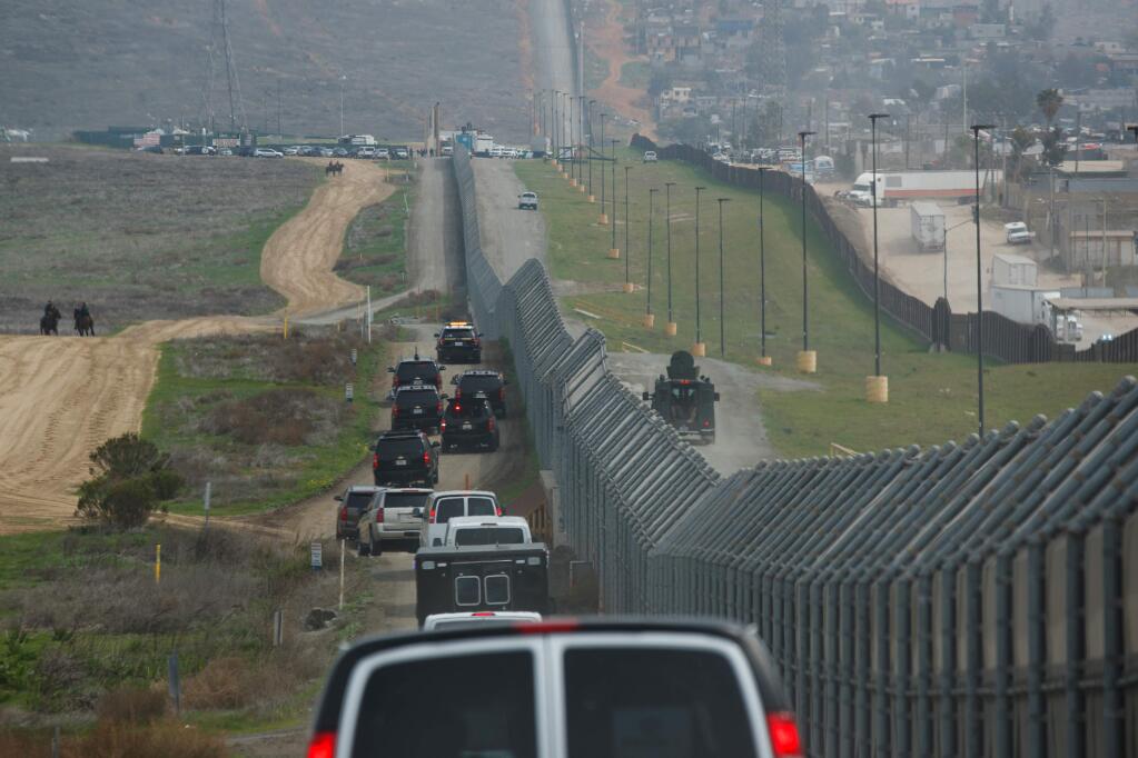 FILE - In this March 13, 2018, file photo, a motorcade carrying President Donald Trump drives along the border in San Diego. California has rejected the federal government's initial plans for National Guard troops to the border because the work is considered too closely tied to immigration enforcement. (AP Photo/Evan Vucci, File)