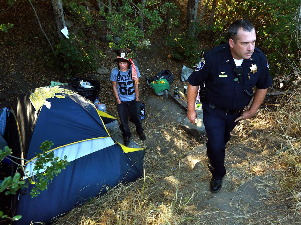 Petaluma Police Lt. Tim Lyons gives notice to a homeless woman she will have to move on from her encampment near the Petaluma River in 2014. (PD FILE)