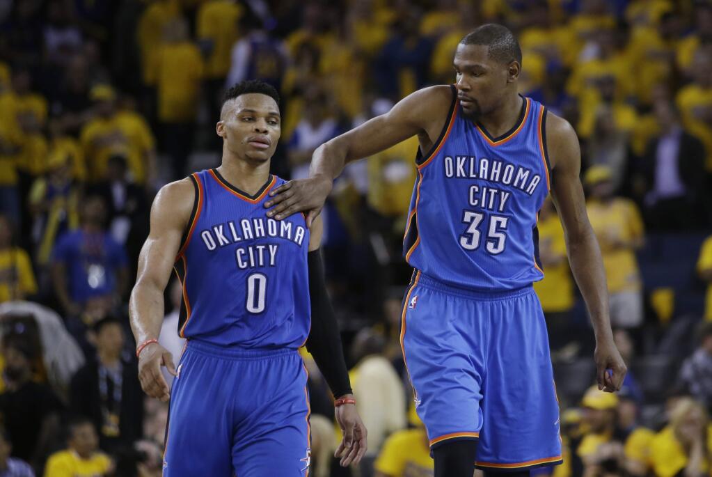 Oklahoma City Thunder's Kevin Durant (35) pats teammate Russell Westbrook (0) on the shoulder as they take a lead over the Golden State Warriors during the second half in Game 1 of the NBA basketball Western Conference finals Monday, May 16, 2016, in Oakland, Calif. Oklahoma City won 108-102. (AP Photo/Marcio Jose Sanchez)