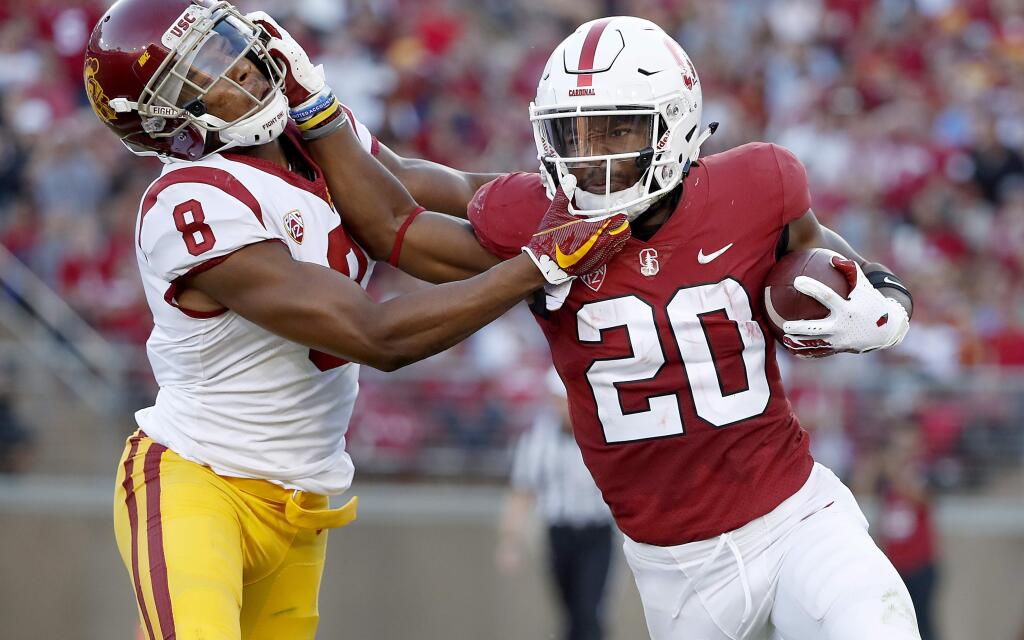 In this Saturday, Sept. 8, 2018 file photo, Stanford running back Bryce Love (20) stiff-arms USC cornerback Iman Marshall (8) during the first half in Stanford. Stanford will get star running back Bryce Love back for this week's Pac-12 North showdown against No. 20 Oregon but the seventh-ranked Cardinal will be without a key defensive player. (AP Photo/Tony Avelar, File)