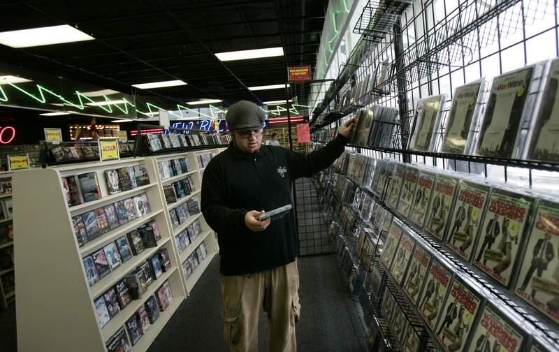 Lede 1 of 1 -- Bradley Video supervisor Gabriel Ramos (cq) re-stocks the new releases shelves of the Rhonert Park store Friday February 3, 2006 in preparation for the weekend rush. (Press Democrat / Chad Surmick)
