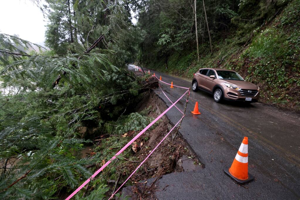 A vehicle drives on a single lane section of Moscow Road near Monte Rio, Calif., Tuesday, January 10, 2023. The westbound lane was damaged Sunday by falling redwoods and a mudslide. (Beth Schlanker/The Press Democrat)