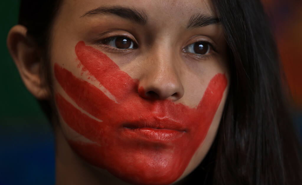 Delainy Sorrell, 15, of Klamath with her handprint painted across her mouth, a symbol to indicate solidarity with missing and murdered Indigenous women and girls, prior to a Missing and Murdered Indigenous Women march in Klamath, Thursday, May 5, 2022. (Kent Porter/The Press Democrat)