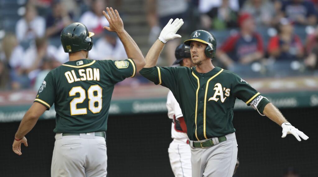 Oakland Athletics' Stephen Piscotty, right, is congratulated by Matt Olson after Piscotty hit a two-run home run in the 11th inning of a baseball game against the Cleveland Indians, Saturday, July 7, 2018, in Cleveland. (AP Photo/Tony Dejak)