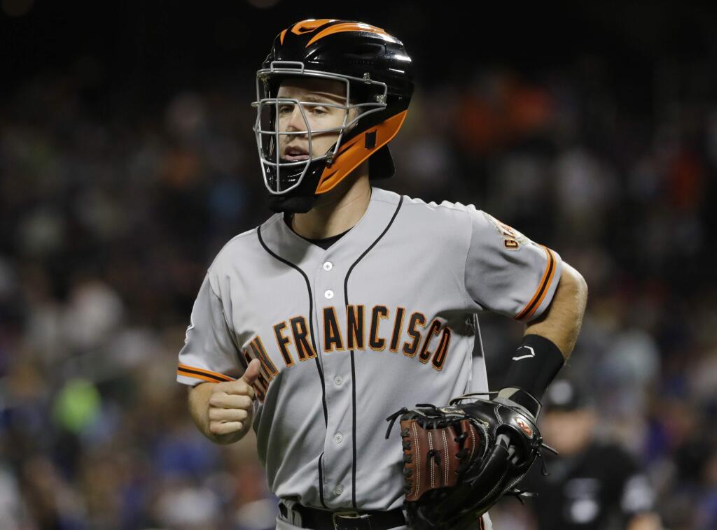 The San Francisco Giants' Buster Posey leaves the field after helping warm up starting pitcher Chris Stratton during the sixth inning, Tuesday, Aug. 21, 2018, in New York. (AP Photo/Frank Franklin II)