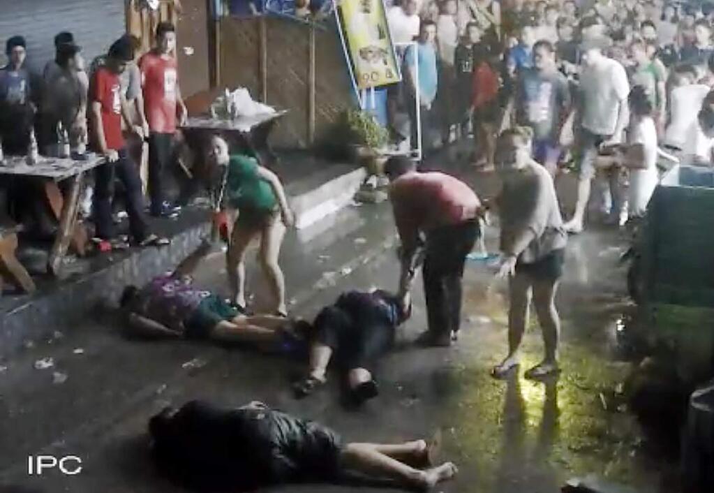 In this April 13, 2016 image taken from video released by the Hua Hin Municipality an elderly British couple and their son are on the ground after they were savagely attacked during a family vacation in Hua, Hin, Thailand. A video of the attack, which was captured by overhead security cameras and posted this week on social media, has stirred shock and outrage over its brutality and the ages of the elder victims, a 65-year-old woman and 68-year-old man from Scotland. The attack marks the latest act of violence against tourists in the Southeast Asian country. (Hua Hin Municipality via AP)