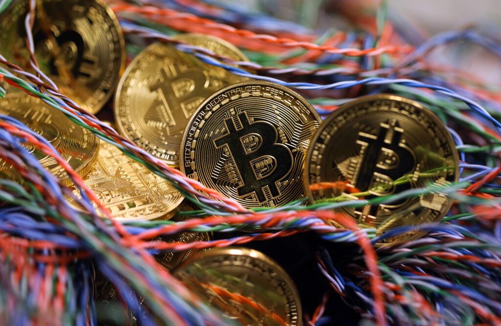 Bitcoins sit among twisted copper wiring inside a communications room at an office in this arranged photograph in London in September. MUST CREDIT: Chris Ratcliffe, Bloomberg