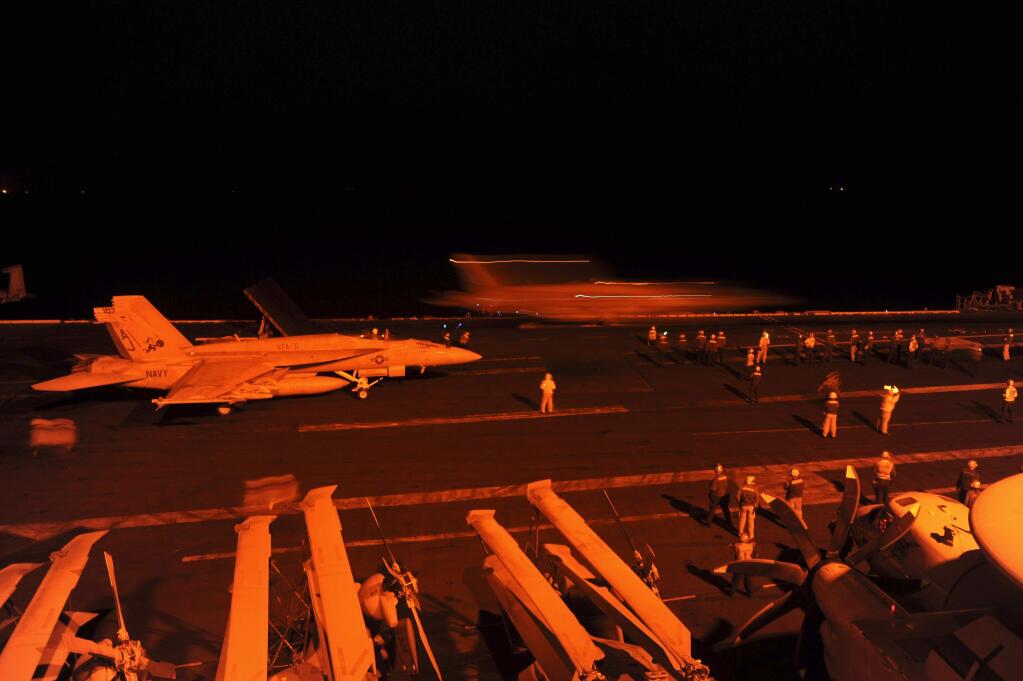 In this photo released by the U.S. Navy, A-18E Super Hornet, attached to Strike Fighter Squadron (VFA) 31, and an F/A-18F Super Hornet, attached to Strike Fighter Squadron (VFA) 213, prepare to launch from the flight deck of the aircraft carrier USS George H.W. Bush (CVN 77) to conduct strike missions against Islamic State group targets, in the Arabian Gulf, Tuesday, Sept. 23, 2014. Syria said Tuesday that Washington informed President Bashar Assad's government of imminent U.S. airstrikes against the Islamic State group, hours before an American-led military coalition pounded the extremists' strongholds across northern and eastern Syria. (AP Photo/Robert Burck, U.S. Navy)