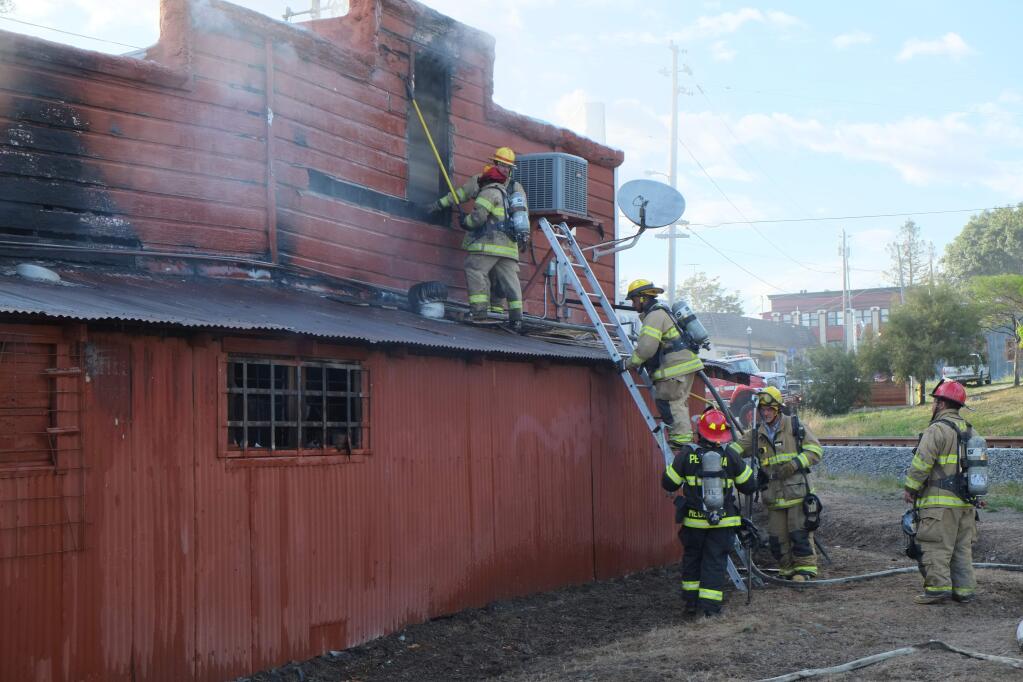Fire fighters battle flames that climbed into the attic of the Penngrove Market building on May 7. ERIC GNECKOW/ARGUS-COURIER