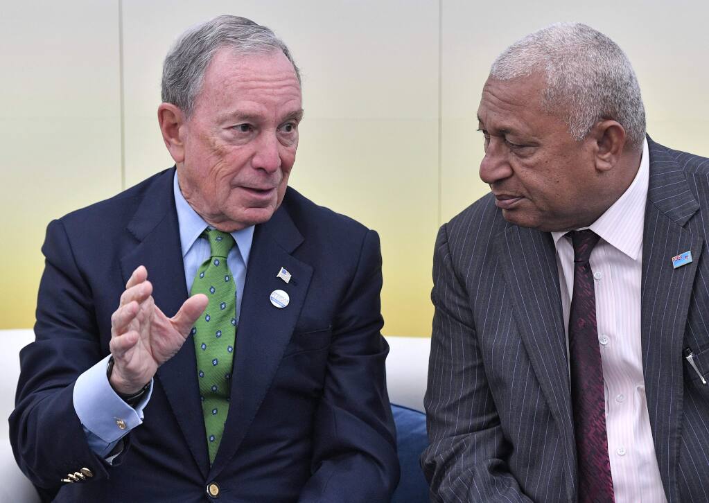 Former New York Mayor and billionaire Michael Bloomberg, left, speaks with Fiji prime minister and COP president Frank Bainimarama in the U.S. Climate Action Center at the COP 23 Fiji UN Climate Change Conference in Bonn, Germany, Saturday, Nov. 11, 2017. Bloomberg's 'America's Pledge' campaign works to compile and tally the climate actions of states, cities, colleges, businesses, and other local actors across the entire U.S. economy. (AP Photo/Martin Meissner)