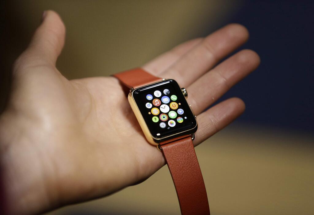 FILE - In this March 9, 2015 file photo, a woman holds the Apple Watch during a demo following an Apple event in San Francisco. The first batch of Apple Watches will arrive in peopleís homes and offices Friday April 24, 2015. (AP Photo/Eric Risberg, File)