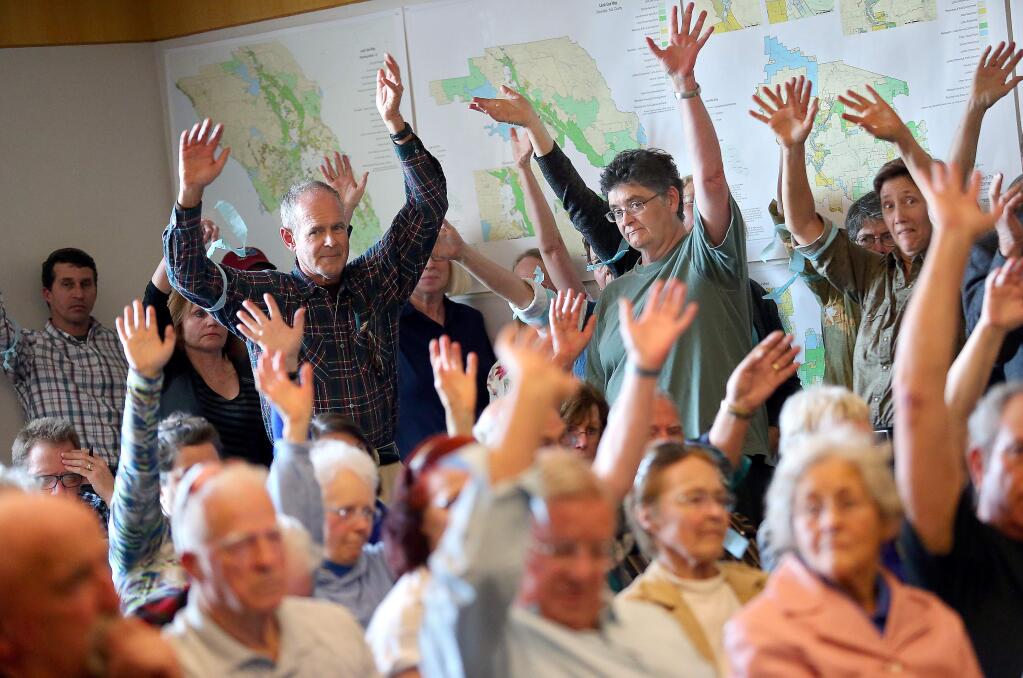 Opponents to Guy Fieri's proposed Willowside Road winery wave their hands in support of a speaker during a public hearing at the Board of Zoning Adjustments and Planning Agency in Santa Rosa on Thursday, January 22, 2015. (Christopher Chung/ The Press Democrat)