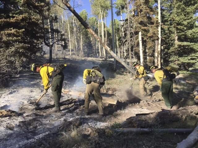 In this July 2017 photo provided by Chubb shows the Wildfire Defense Systems, Inc. firefighters mop up spot fires on a client's property during a wildfire in Panguitch, Utah. Among the army of firefighters protecting entire neighborhoods at the front lines of Southern California's monstrous wildfire are teams hired by insurance companies that offer personalized prevention and protection services for individual homeowners. (Wildfire Defense Systems, Inc via Chubb via AP)
