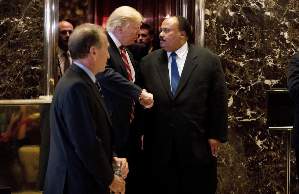 President-elect Donald Trump shakes hands with Martin Luther King III, son of Martin Luther King Jr. at Trump Tower in New York, Monday, Jan. 16, 2017. Also pictured is William Wachtel, left. (AP Photo/Andrew Harnik)